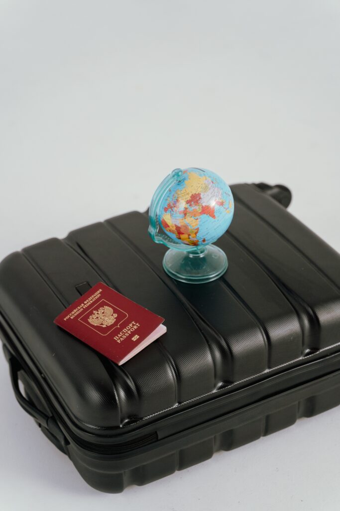 valise noire rigide de voyage avec un passeport et un globe terrestre